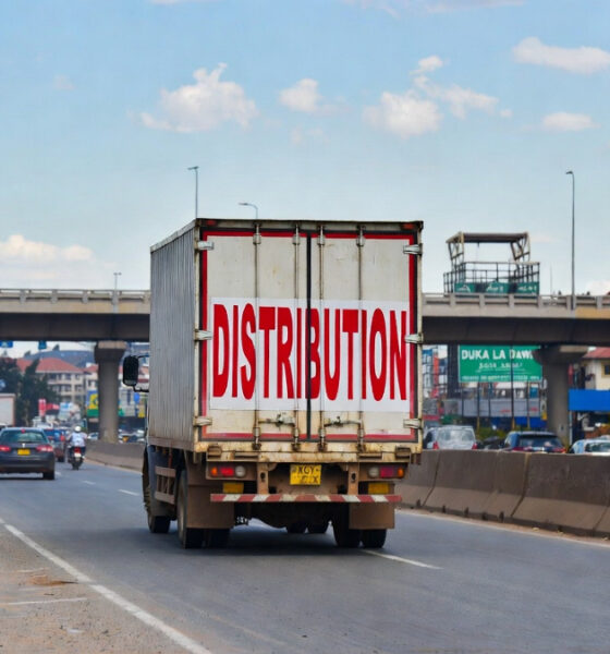A logistics truck navigating a busy Kenyan market street, representing the challenges and opportunities of distribution strategy for international manufacturers entering the East Africa consumer market.