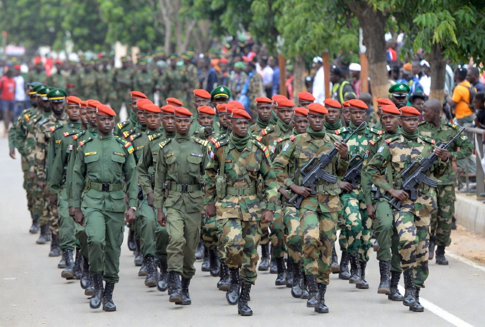 Chadian military troops march in formation during a deployment ceremony, representing Chad's 1,500-strong contingent committed to Haiti's Gang Suppression Force