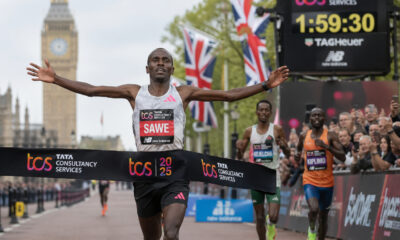 Sebastian Sawe crossing the finish line at the London Marathon, breaking the sub-two-hour marathon record with a historic 1:59:30 performance amid cheering crowds.