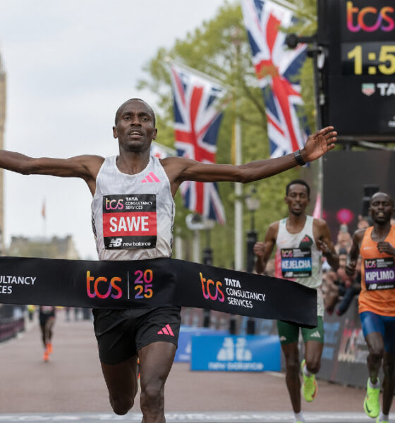 Sebastian Sawe crossing the finish line at the London Marathon, breaking the sub-two-hour marathon record with a historic 1:59:30 performance amid cheering crowds.