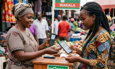 African woman using mobile phone for mobile money payment at a market in Lusaka, Zambia.