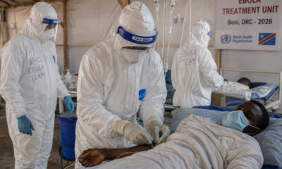 Health workers in hazmat suits treating Ebola patients at a medical facility in the Democratic Republic of Congo during the 2026 outbreak.