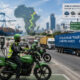 Electric motorcycles and charging stations in an African city alongside cargo trucks moving goods from East African ports to Central Africa, illustrating Africa’s EV ecosystem, critical minerals, and regional trade logistics opportunity