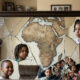 Cracked mirror reflecting both African motherland and scattered diaspora children, symbolizing wholeness.