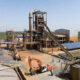 African mineral processing plant with workers and heavy machinery, highlighting the need for sustainable industrialization and reliable infrastructure across the continent.