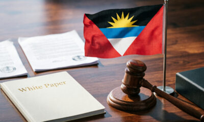 Antigua and Barbuda flag beside a courthouse gavel, symbolizing the nation's sovereign stand on U.S. Third-Country Nationals deportation talks