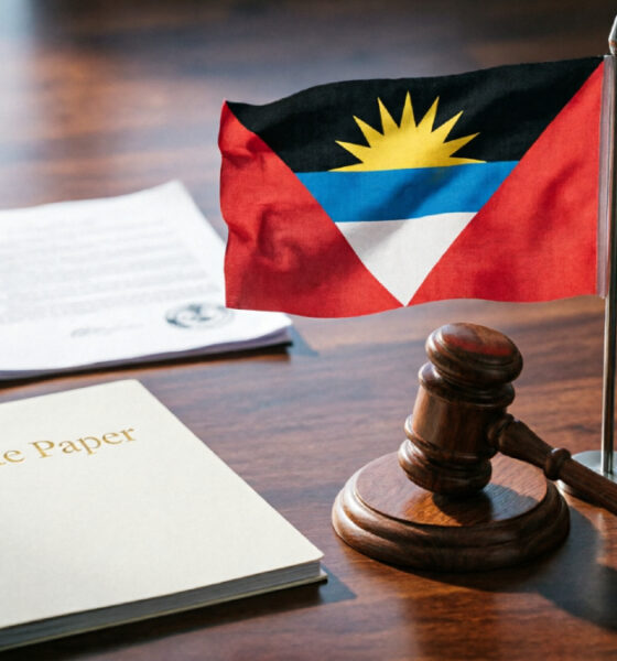 Antigua and Barbuda flag beside a courthouse gavel, symbolizing the nation's sovereign stand on U.S. Third-Country Nationals deportation talks