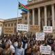 Citizens of an African country gathered and protesting outside a government building, reflecting declining public trust amid Africa's leadership crisis