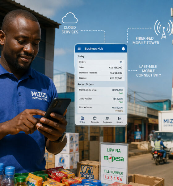 African distributor running a business from a smartphone as a cell tower delivers fiber-fed mobile broadband