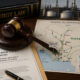 Gavel resting on legal documents beside a map of Nigeria's oil infrastructure, symbolizing the courtroom battle over the Dangote refinery monopoly and fuel-import licenses