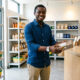Young African entrepreneur serving customers at a local shop, showing trust in African businesses