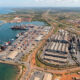 Aerial view of an African port and factory complex linked by regional trade routes.