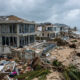 Storm-damaged Caribbean coastal homes reflecting the region's climate debt burden after the 1.5°C breach