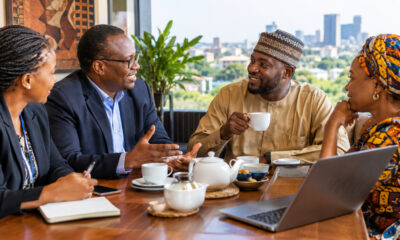 Business professionals building trust over tea during an Africa market entry strategy meeting.