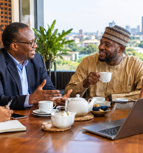 Business professionals building trust over tea during an Africa market entry strategy meeting.