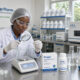 Lab technician performing quality control on Drepaf hydroxyurea capsules for sickle cell treatment at Teranga Pharma laboratory in Senegal